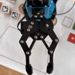 Gripper below a camera