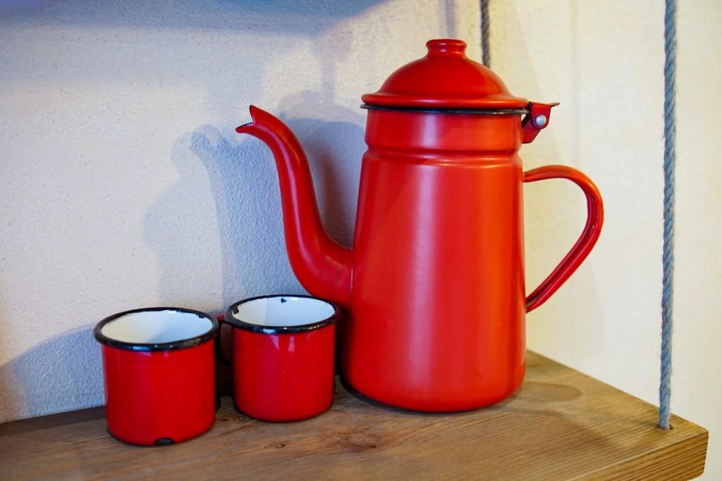 Red enamel coffee pot and two cups