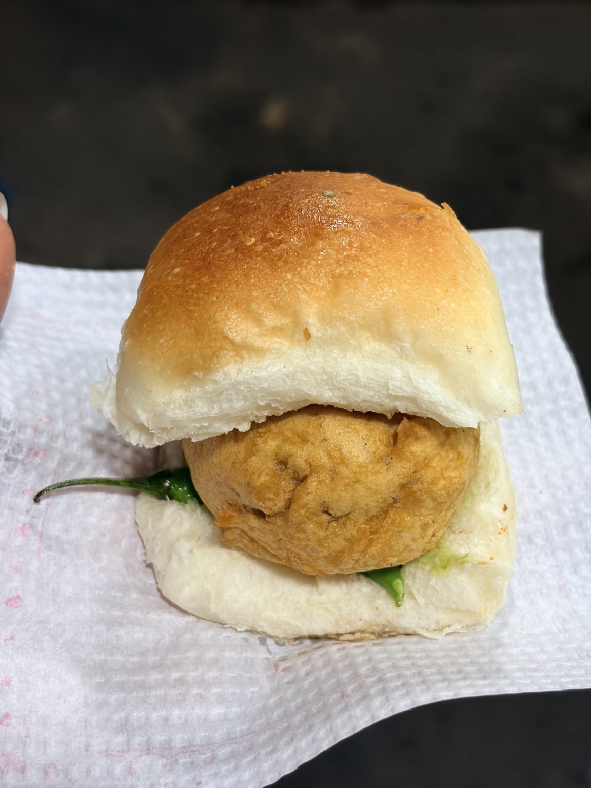 Authentic Mumbai vada pav from a street vendor, served on a tissue.